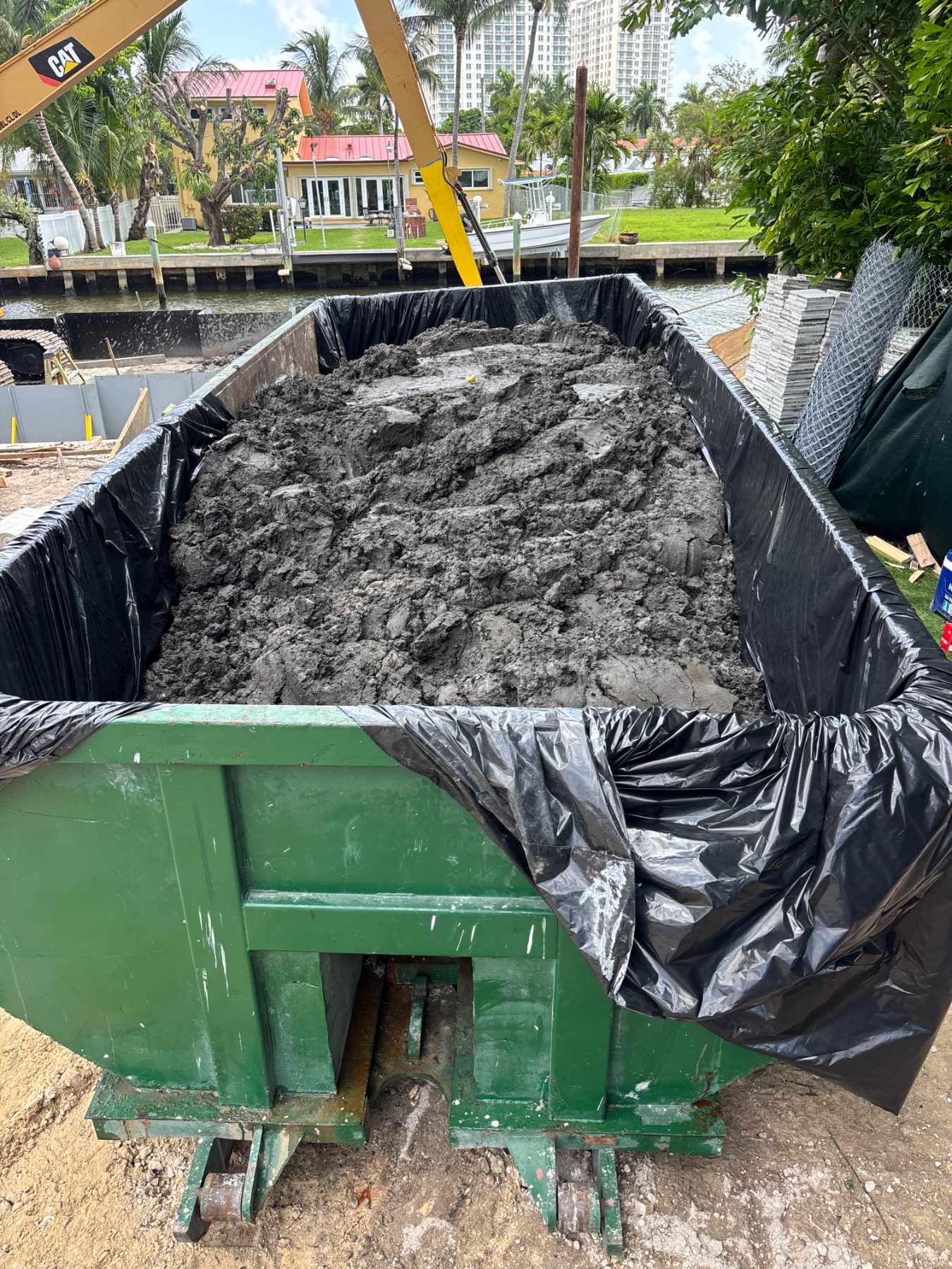 Sealed bin loaded with dredge material at a shipyard